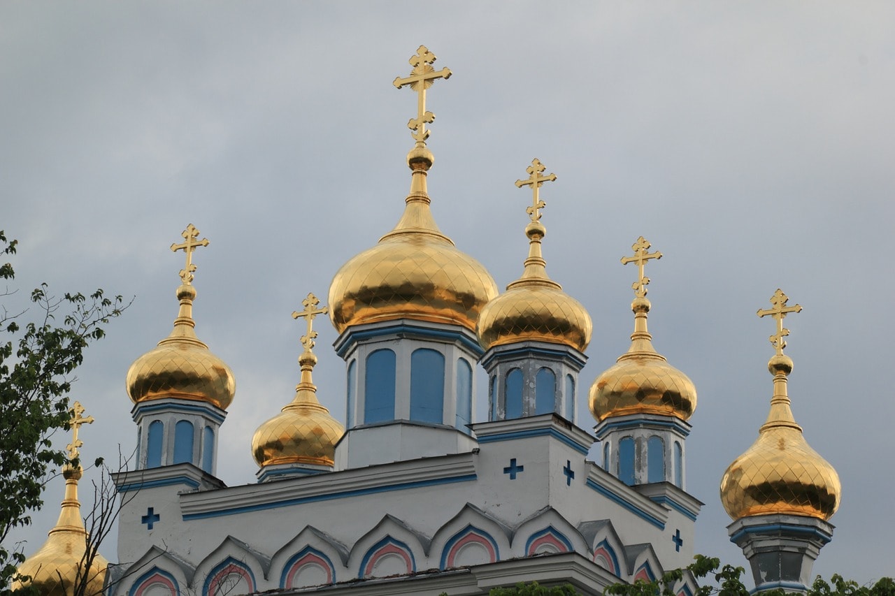 Un vol Lettonie pas cher avec Algofly illustré par une église orthodoxe à dômes dorés.