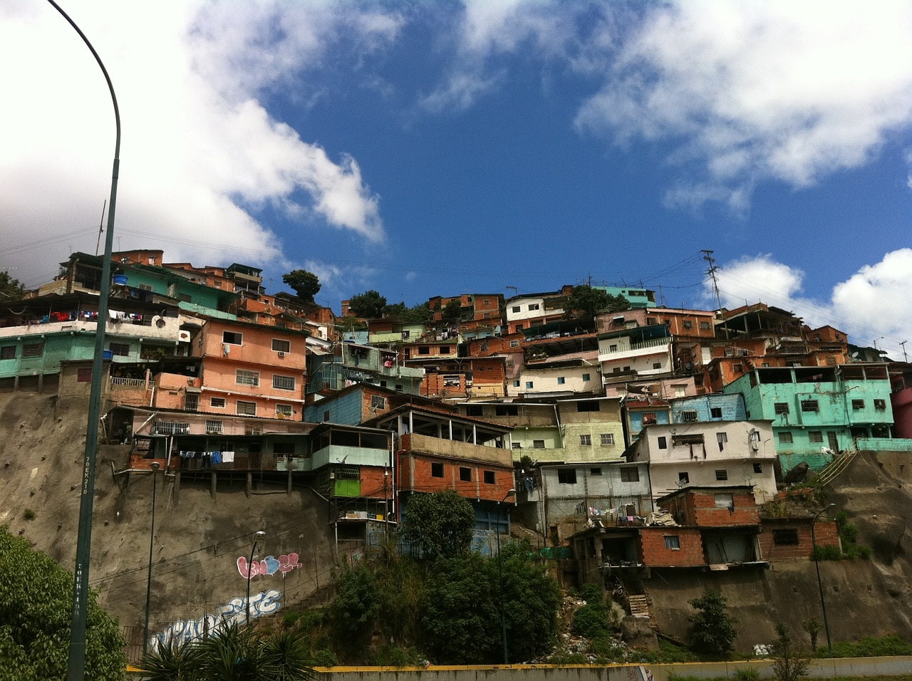 Un vol Venezuela pas cher avec Algofly illustré par des maisons de couleurs entassées sur une colline.